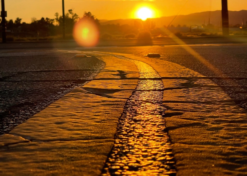 winding road leading to a sunset