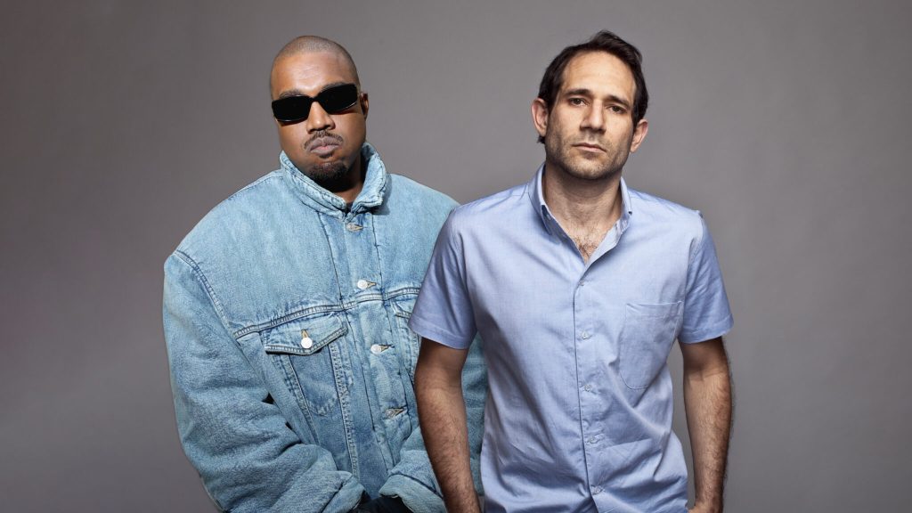 Kanye West in black sunglasses standing next to Dov Charney 