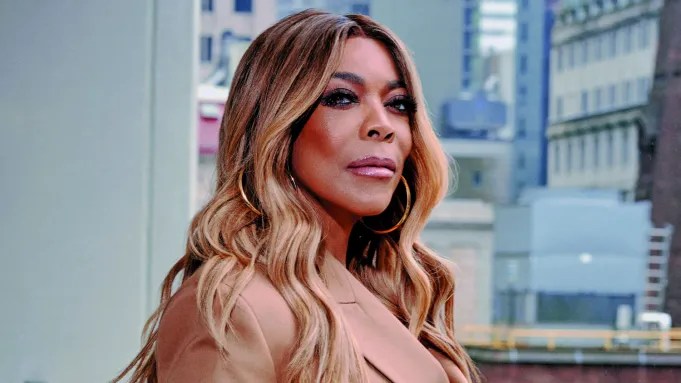 Wendy Williams staring intensely into camera with bold makeup and large golden hoops