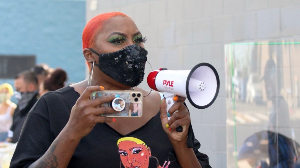 Shirley Raines wearing mask speaking into megaphone 